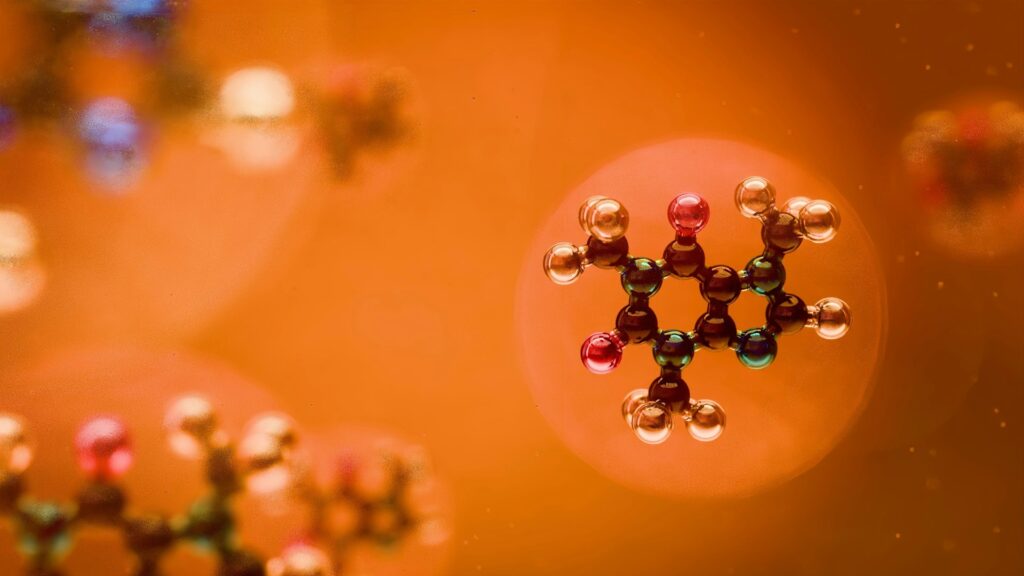 3D ball-and-stick model of a small molecule on an orange background