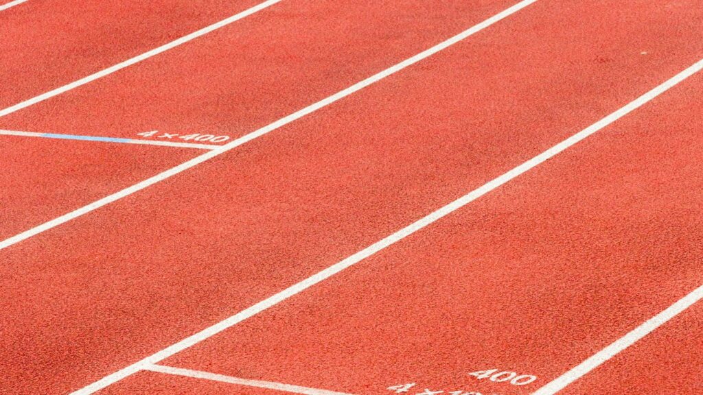 AMPK: The Energy Sensor Behind Metabolic Peptide Research 1 Close-up of a red synthetic running track surface with white painted lane markings