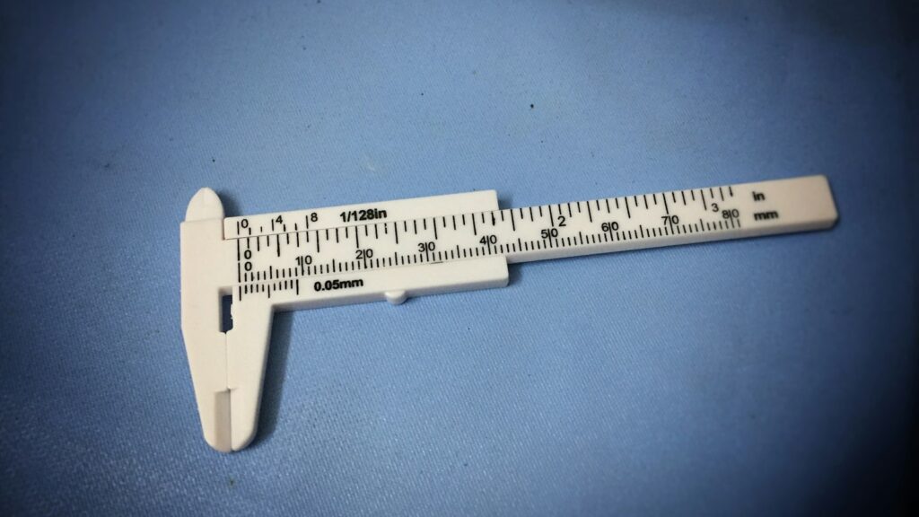 Analytical Method Validation: Why a Purity Number Depends on Its Method 1 A vernier caliper lying on a blue surface, its measurement scale in focus