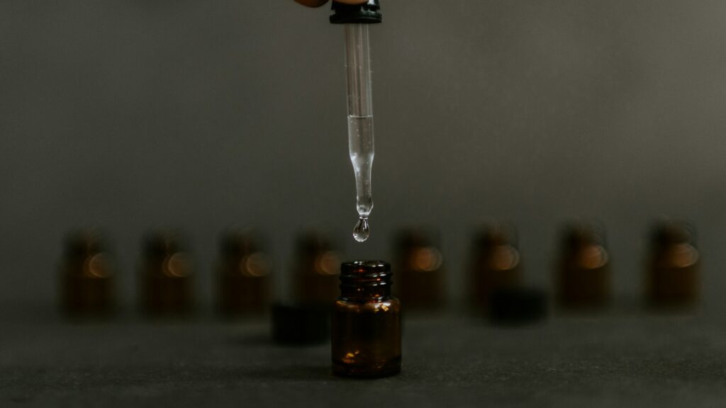 Clear drop falling from a glass dropper