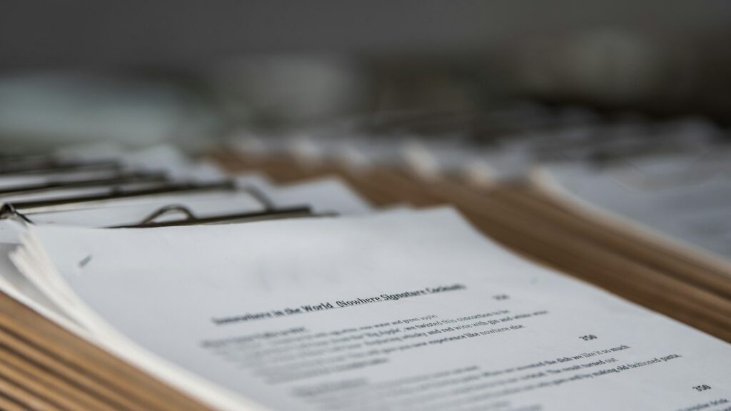A stack of printed documents on a desk, shown in shallow focus