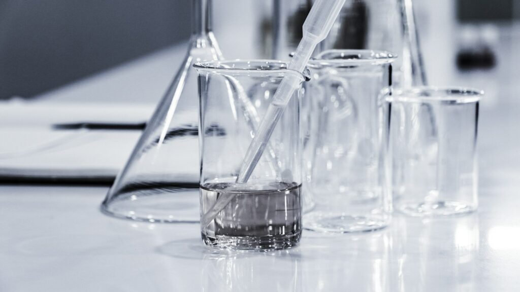GHK-Cu Copper Peptide: What the Research Shows 1 Three clear glass beakers on a laboratory bench, illustrating GHK-Cu copper peptide research