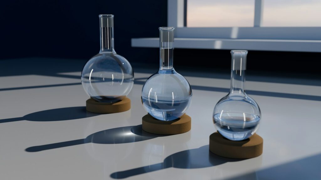 GSH vs GSSG: Reduced and Oxidized Glutathione in the Laboratory 1 3D render of three transparent round-bottom laboratory flasks on cork stands on a white surface