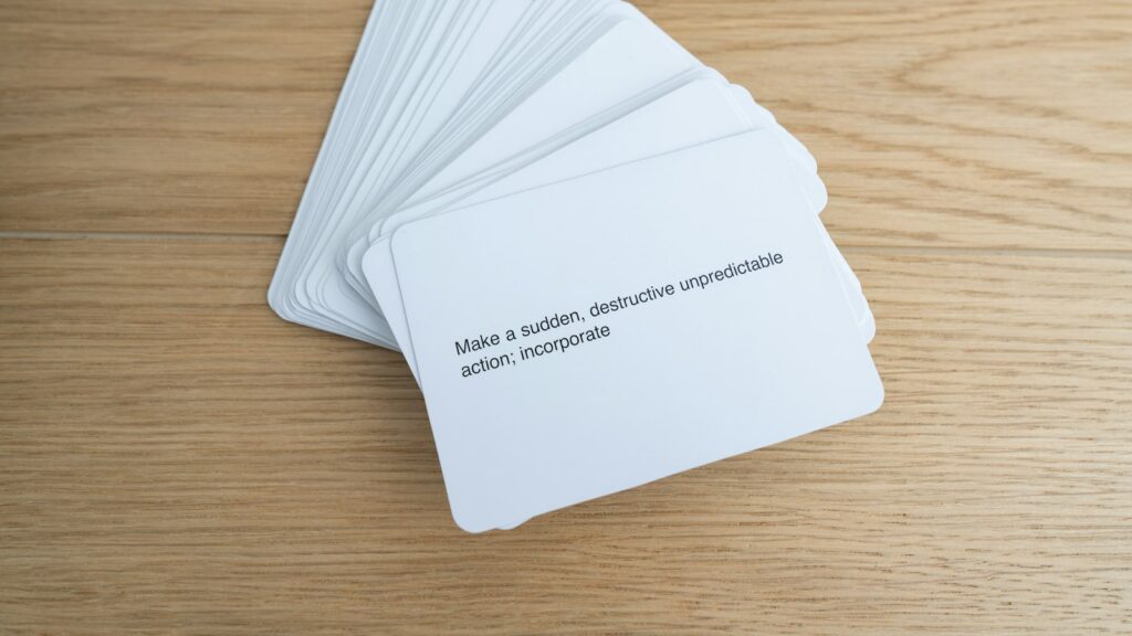 A stack of white cards with text on a light wooden surface