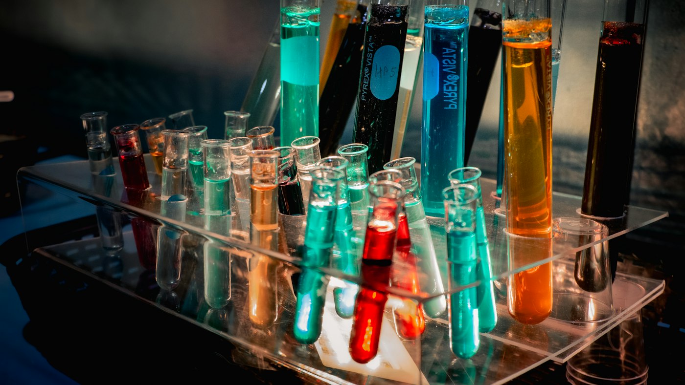Test tubes filled with different coloured liquids in a laboratory rack